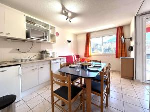 een keuken en eetkamer met een tafel en stoelen bij Appart 2 pièces 4 pers, proche Prorel, balcon, parking - FR-1-330C-5 in Briançon