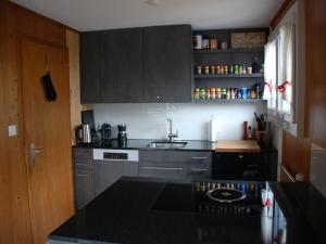 a kitchen with a black counter top and a sink at Apartment Casa Mira by Interhome in Engelberg