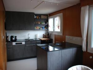 a kitchen with gray cabinets and a counter top at Apartment Casa Mira by Interhome in Engelberg