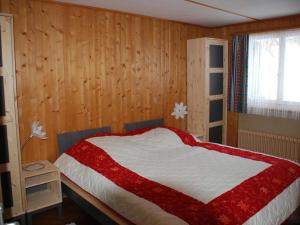 a bedroom with a bed with a red and white blanket at Apartment Casa Mira by Interhome in Engelberg +6 photos