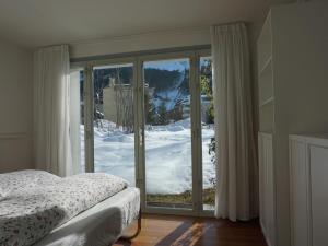a bedroom with a bed and a sliding glass door at Apartment Bergfried by Interhome in Engelberg +10 photos