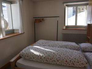 a bedroom with two beds and two windows at Apartment Bergfried by Interhome in Engelberg