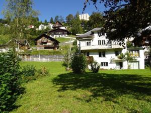 a group of houses on a hill with a grass field at Apartment Bergfried by Interhome in Engelberg