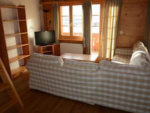 a living room with a couch and a tv at Apartment Jacqueline 22 by Interhome in Gstaad