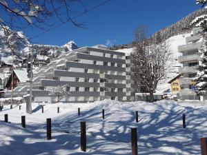 un gran edificio en la nieve con una montaña en Apartment Sunnmatt 752 by Interhome, en Engelberg