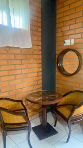a table and two chairs next to a brick wall at Cantinho da Tia Dori in Rio Forcação