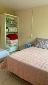 a bedroom with a bed and a closet at Cantinho da Tia Dori in Rio Forcação