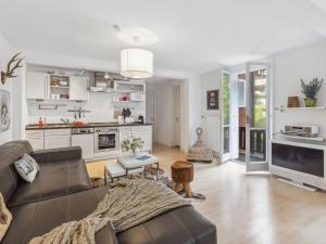 Una sala de estar con un sofá y una cocina. en Apartment Bristol Apt-S by Interhome, en Wengen 30 fotos más