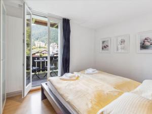 Un dormitorio con una cama grande y un balcón. en Apartment Bristol Apt-S by Interhome, en Wengen