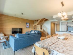 a living room with a blue couch and a table at Duplex 4 pièces Les Arcs 1600, Piscine, SPA, pied de pistes - FR-1-461A-7 in Arc 1600