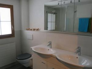 a bathroom with a sink and a toilet and a mirror at Apartment Chalet Heureka-Horbis by Interhome in Engelberg