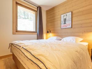 a bedroom with a large bed with a window at Duplex 4 pièces Les Arcs 1600, Piscine, SPA, pied de pistes - FR-1-461A-7 in Arc 1600 +28 photos