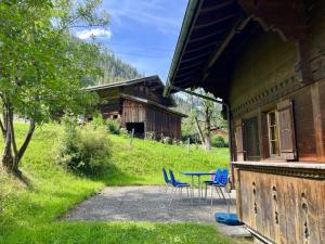 una mesa y sillas sentadas fuera de una cabaña en Apartment Akelei - gross by Interhome, en Zweisimmen