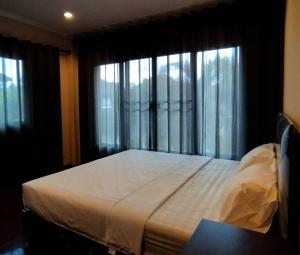 a bedroom with a large bed in front of a window at CHILLI's Homes2 in Chiang Mai