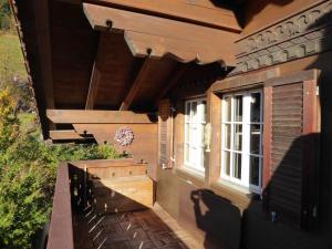 a porch of a house with a bench and a window at Apartment Résidence Sonnegg - Herrli by Interhome in Zweisimmen
