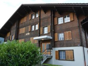 a large wooden building with windows and a staircase at Apartment Résidence Sonnegg - Herrli by Interhome in Zweisimmen