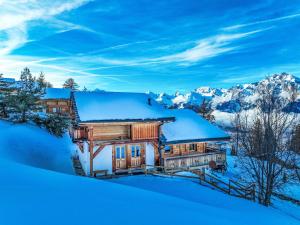 a home covered in snow with mountains in the background at Chalet Gingembre 12 by Interhome in Nendaz