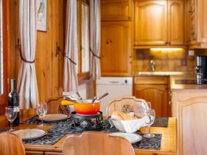 een keuken met een tafel met borden en wijnglazen bij Chalet Als man zählte 1989 by Interhome in Gasenried