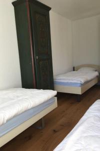 a room with two beds and a green cabinet at Apartment Turmalin 2- Stock by Interhome in Lenk