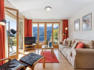a living room with a couch and a tv at Apartment Silberhorn Apt- V by Interhome in Wengen