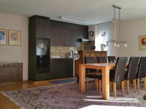 a kitchen and dining room with a wooden table and chairs at Apartment Alpenstrasse 621 by Interhome in Engelberg