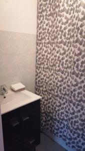 a bathroom with a shower curtain and a sink at Madeira property in Câmara de Lobos