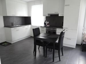 una cocina con mesa negra y sillas. en Apartment Barbara Ost by Interhome, en Engelberg