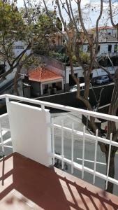 a balcony with a white railing and a tree at Madeira property in Câmara de Lobos