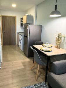 een keuken en eetkamer met een tafel en een koelkast bij Vuela Casa 2 in Noord Pattaya