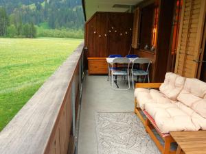 a porch with couches and tables and chairs on a house at Apartment Chalet Lerchweid Lenk by Interhome in Lenk +42 photos