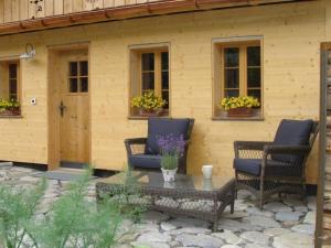 two chairs and a table in front of a house at Apartment Gwunderstübli by Interhome in Lenk