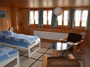 a bedroom with a bed and a table and a chair at Apartment Obegghuus by Interhome in Zweisimmen