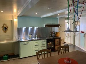 a kitchen with white cabinets and a table with chairs at Apartment Obegghuus by Interhome in Zweisimmen