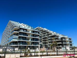 a tall building with palm trees in front of it at Suite Terraza Estreno in Cabanes