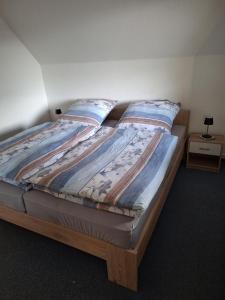 a bed in a room with two pillows on it at NEU! Ferienwohnung Friesland Zetel in Zetel