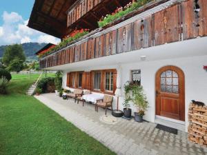 a building with a table and chairs in a yard at Apartment Chalet Bodenweg by Interhome in Frutigen