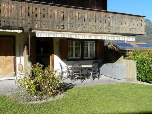 a patio with a table and chairs in front of a house at Apartment Résidence Sonnegg - Puric by Interhome in Zweisimmen