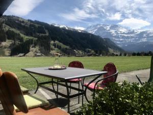 a table and chairs with a view of a mountain at Apartment Lischenhaus 2 - Wohnung Flösch by Interhome in Lenk