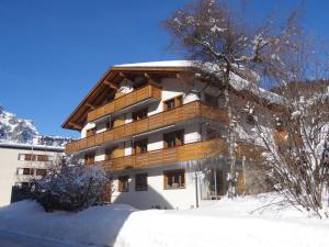 a building with snow on the ground in front of it at Apartment Alpenstrasse 1 by Interhome in Engelberg