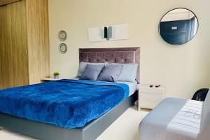 a bedroom with a bed with a blue comforter and a mirror at 9804 · 9804 Loft Env. good view local experience confort in Envigado