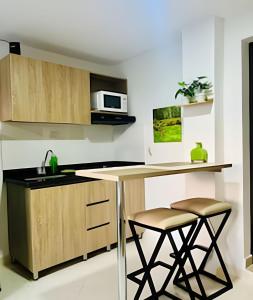 a kitchen with a counter and two stools at 9804 · 9804 Loft Env. good view local experience confort in Envigado +4 photos