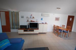 a living room with a couch and a tv and a table at Apartment Grozic in Porat