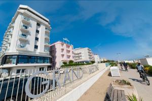 a building on the beach with people riding bikes at Grand Meeting Hotel in Rimini +33 photos
