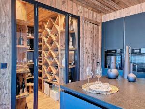 a wine cellar with two wine glasses on a counter at Chalet La Panthère des Neiges in Saint-Martin-de-Belleville