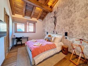 a bedroom with a bed with a teddy bear on it at Chalet La Panthère des Neiges in Saint-Martin-de-Belleville