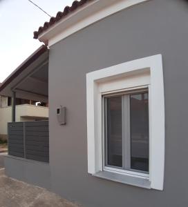a window on the side of a white building at Boutique maison Filiatra in Filiatra