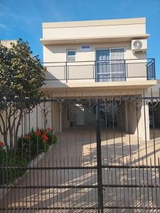 a white house with a fence in front of it at Departamentos Los dos Pinos in San José