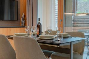 a dining table with glasses and a bottle of wine at Borgo PLAZA CHALET in Bormio