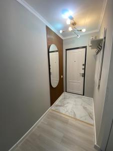a hallway with a white door and a mirror at Люксовая квартира in Taraz