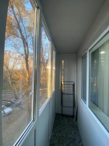 an empty room with a window with a view of a tree at Люксовая квартира in Taraz